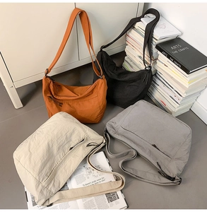 Detail showing orange black beige and grey nylon crossbody bags in a casual lifestyle setting