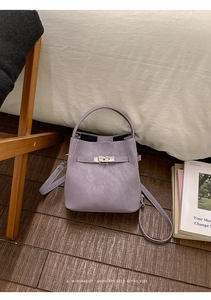 Detail of lavender bucket bag showing classic metal swivel clasp and lychee leather texture