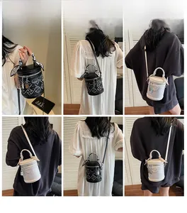 Detail of cylinder bucket bag featuring geometric embossing and silk scarf handle decor