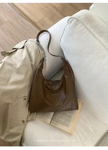 Detailed close-up of dark brown hobo bag featuring retro leather texture and silver chain
