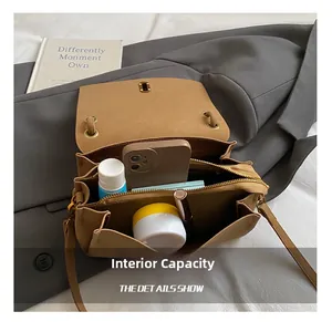 Vue intérieure du sac bandoulière marron montrant les compartiments de rangement spacieux