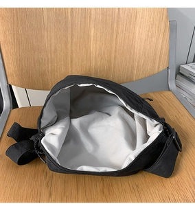 Detail of black nylon crossbody bag interior with wide zipper opening and large capacity