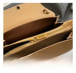 Détail de la fermeture éclair dorée KOSK et du compartiment interne du sac bandoulière brun