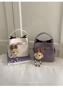Detail of cream and purple bucket bags with bear charms and decorative twist locks