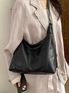 Large black minimalist leather tote bag for women shown as a stylish shoulder bag