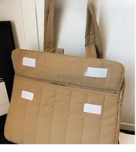 Detailansicht der khakifarbenen Stepptasche mit einem robusten weißen Klettverschluss