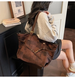 Detailed shot of large brown tote bag with pixelated abstract texture and leather straps