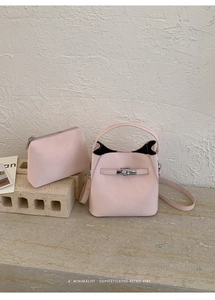 Detail of light pink pebble leather bucket bag with silver twist lock and inner pouch