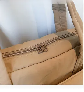 Detailansicht des glatten Doppelreißverschlusses an einer khakifarbenen Nylon-Tragetasche