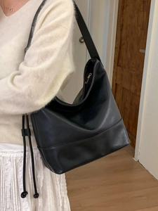 Minimalist black large capacity PU leather shoulder bag for women on model in home setting