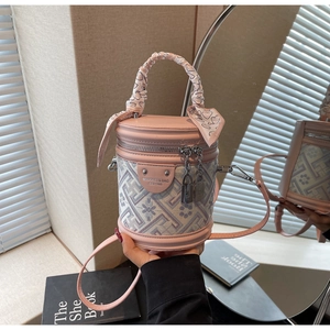 Detail of a pink leather and floral jacquard bucket bag with silk scarf on the top handle