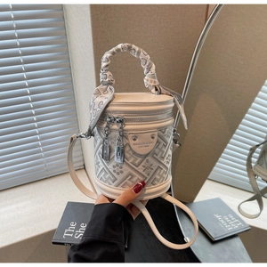 Detail view of cream bucket bag with floral embroidery and heart silk scarf handle