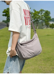 Detailed side view of a grey-purple nylon crossbody bag showing the adjustable strap