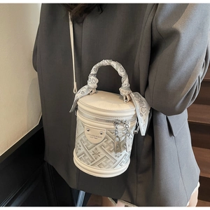 Detail of off-white bucket bag with geometric jacquard and heart print scarf handle