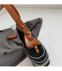 Detail of premium silver hardware on large canvas bucket bag with brown leather straps