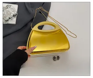 Golden acrylic mirror box bag with chain strap shown beside a phone for size comparison