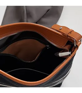 Detail view of the interior compartment featuring a smooth zipper and leather trim piping