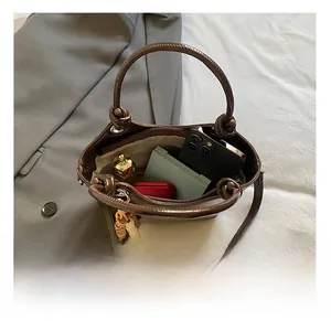 Capacité interne pratique du sac seau marron montrant téléphone et cosmétiques