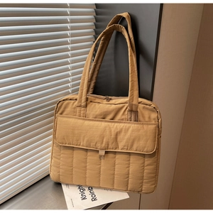 Detailansicht der khakifarbenen Stepptasche mit vertikalen Nähten und Fronttasche