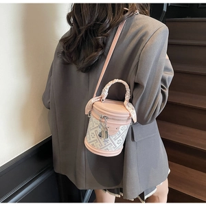 Detail of a pink and white cylinder bucket bag with heart scarf handle on a model
