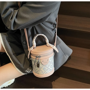 Detailed shot of bucket bag with floral jacquard fabric and pink leather strap