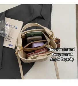 Interior view of cream bucket bag showing compartments with phone and wallet inside