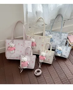 Detalle de bolsos tipo tote con dibujos animados y colgantes de ositos de peluche