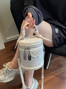 Elegant white bucket bag with gray geometric pattern and silk scarf handle detail