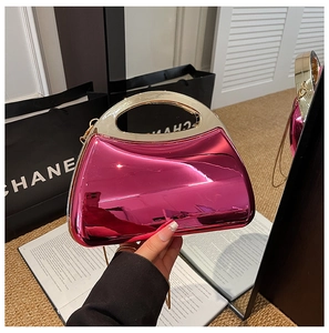 Detail of a bright rose pink metallic acrylic clutch with a stylish gold round handle