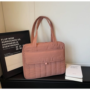 Detailaufnahme der rosa gesteppten Tragetasche mit vertikalen Nähten auf Display