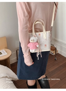 Detalle de bolso tote blanco con textura arrugada, oso de dibujos y colgante de peluche
