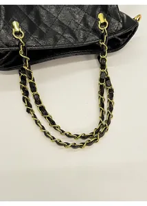 Vue détaillée de la chaîne dorée entrelacée de cuir noir sur le sac matelassé élégant