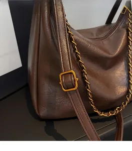 Detail showing adjustable shoulder strap and texture of brown oil wax leather tote bag
