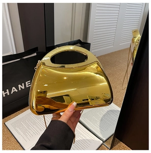 Close-up of golden mirror acrylic handbag with a semi-circle handle and chain strap