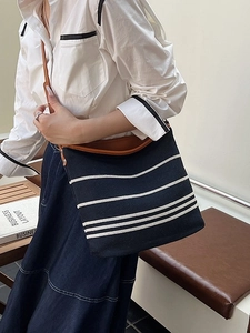 Modern casual black canvas tote bag with white stripes and brown leather strap details