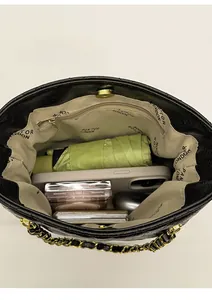 Vue intérieure du sac seau matelassé noir montrant l'espace pour maquillage et mobile
