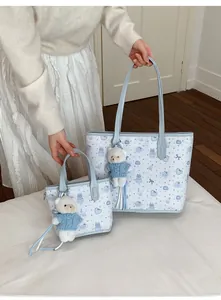 Detalle del juego de bolsos acolchados con osos azules y un colgante de peluche