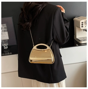 Glossy gold acrylic clutch bag with a semi-circular handle and metal chain shoulder strap