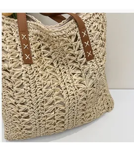Detail of hand-woven straw tote with brown PU leather handles and secure top zipper closure