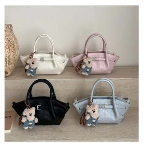 Detail shot of stylish bucket bags in four colors with cute teddy bear charms