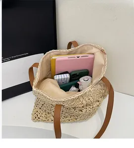 Detail view of large straw tote bag interior showing capacity for tablets and essentials
