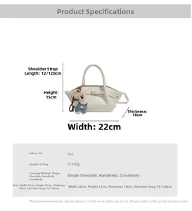 Detail of off-white PU bucket bag with bear charm and adjustable shoulder strap