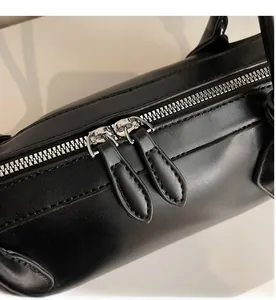 Detail view of the smooth dual silver metal zippers on this black French baguette bag