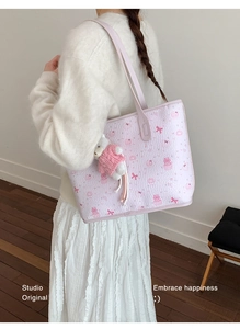 Detalle del bolso rosa con estampados animados y colgante de oso llevado por una modelo