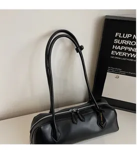 Detailed view of the black Boston bag featuring smooth faux leather and gold JL CHIC logo