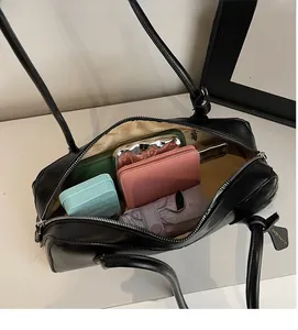 Interior view of black leather baguette bag showing storage for umbrella and wallet