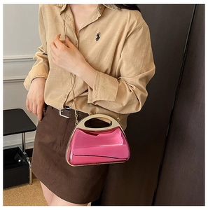 Detailed macro view of the glossy rose pink acrylic evening bag with gold chain and handle