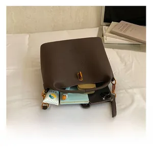 Sac seau en cuir grainé marron foncé montrant l'espace intérieur pour objets
