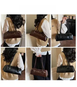 Classic baguette bag with long cylindrical shape and thin double straps in black and brown