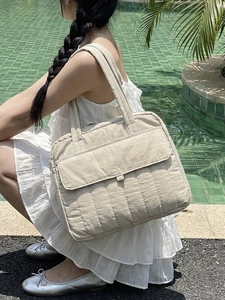 Schicke beige gesteppte Tragetasche mit Fronttasche in einer Outdoor-Pool-Umgebung